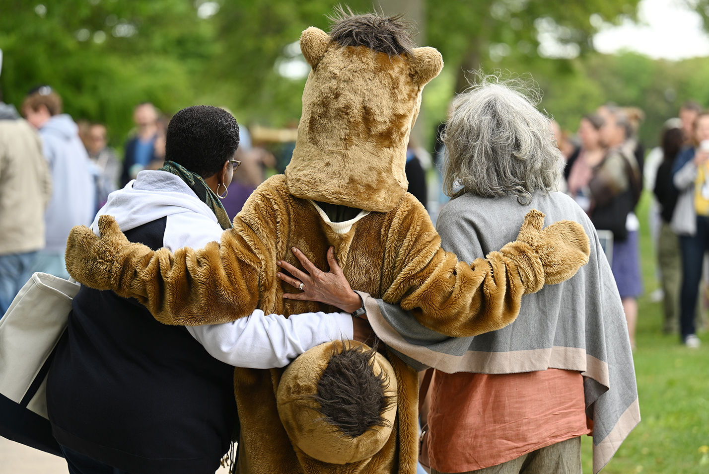 From the back the camel hugs two alumni