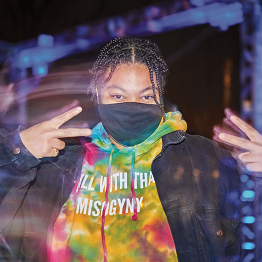 Shot of student in mask in front of Dune stage at night