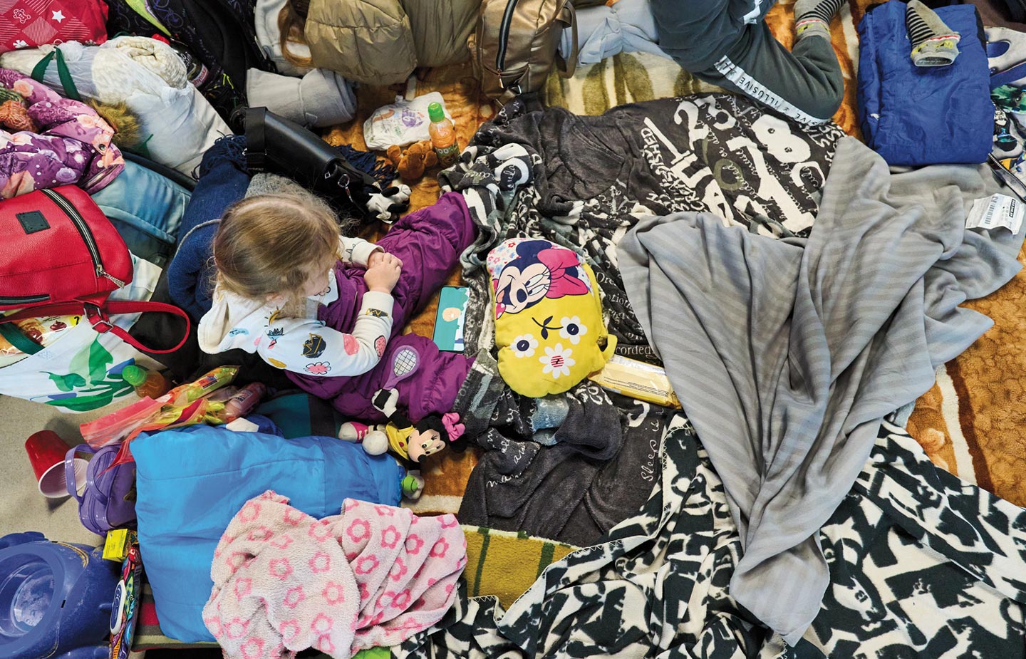 Image of young girl sitting among her scattered belongings