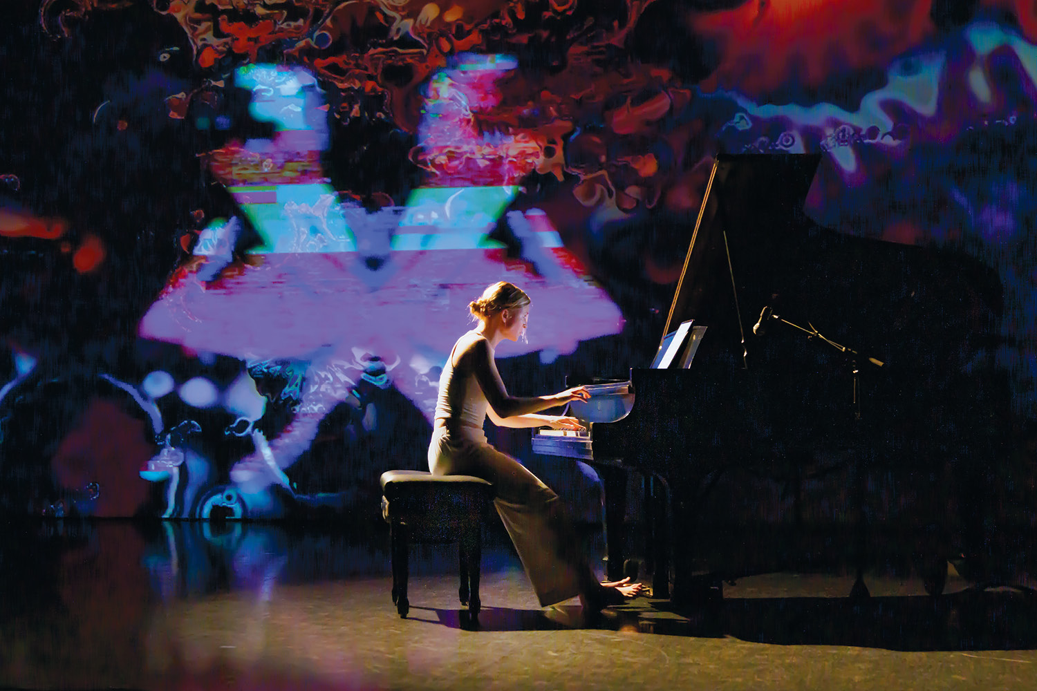 Student playing piano with colored lights in background