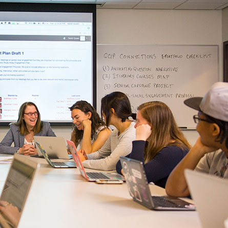 Students sitting around a table with laptops