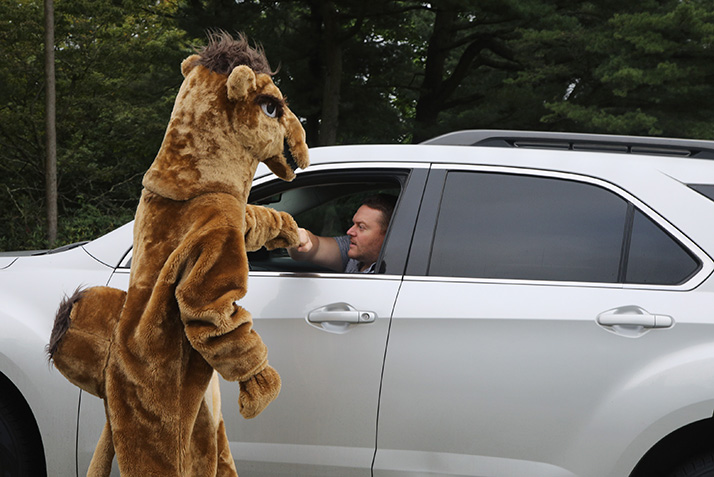 The Camel mascot shakes the hand of a father arriving on campus. 