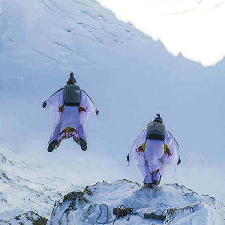 Two base jumpers on a mountainside