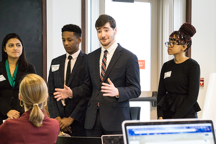 James Murray '20 presents to Cara and Andrew Sawyer as other members of his team look on. 