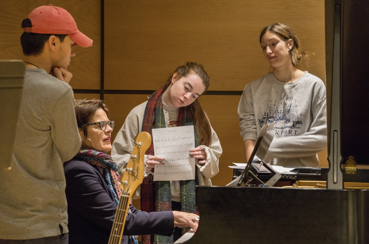 President Bergeron playing piano with students singing