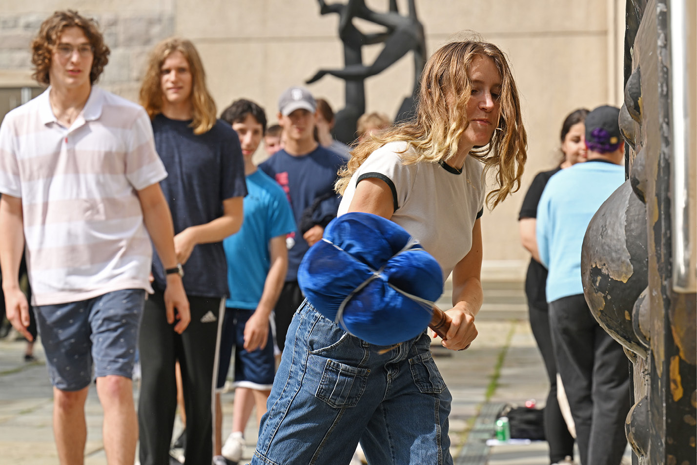 A female student rings the gong in Castle Court.