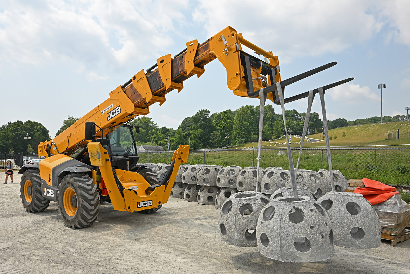 A bucket loader lifts reef balls at the Thames River landing area