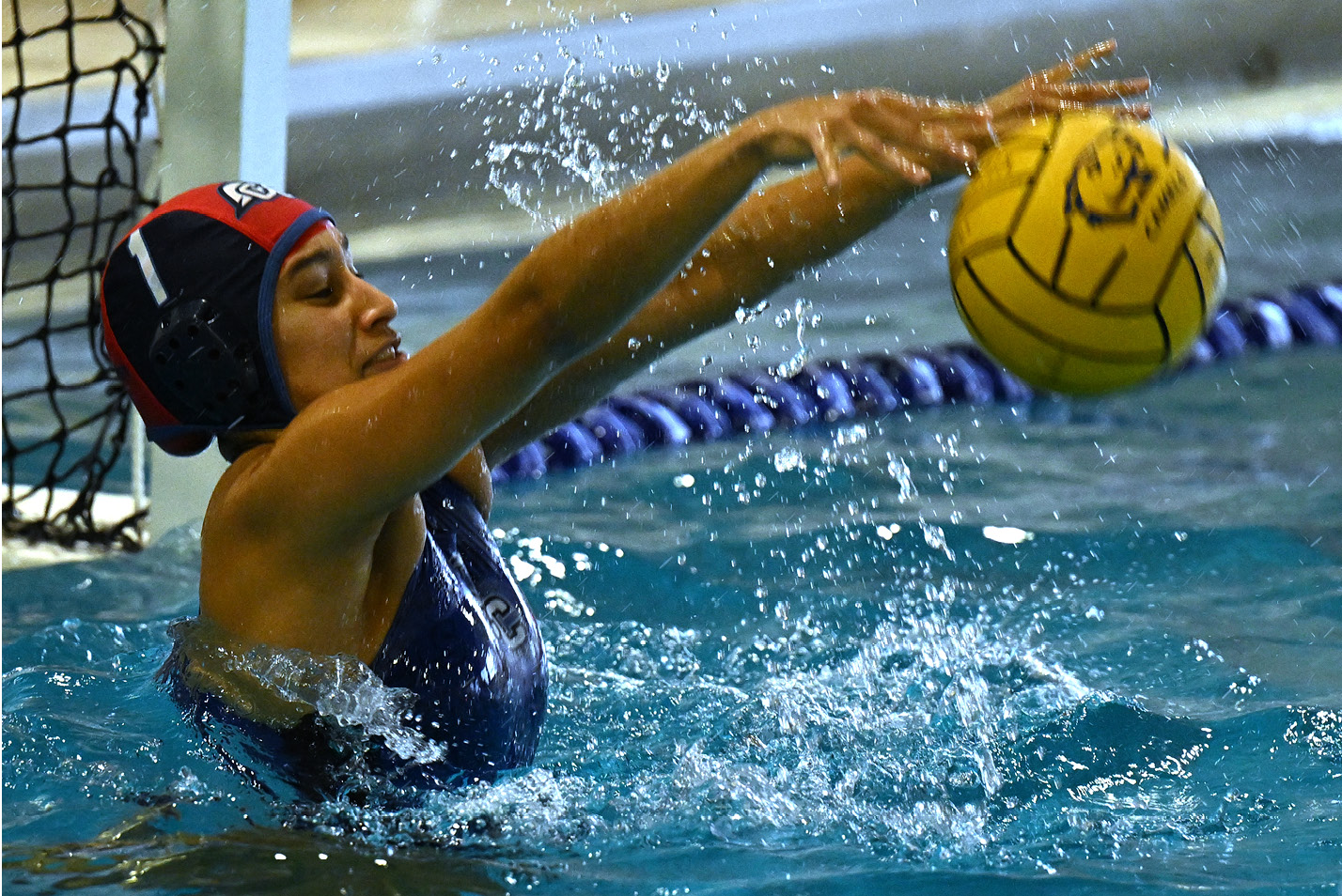 Women's Water Polo goalkeeper blocks the shot.