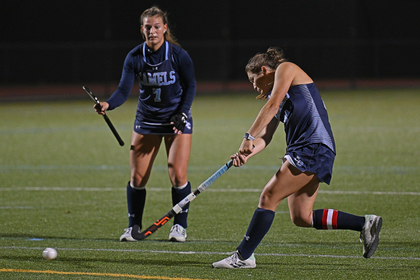 Women's field hockey player takes a shot