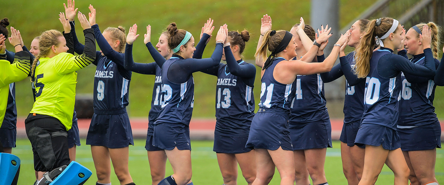 Members of the field hockey team cheer before a game.