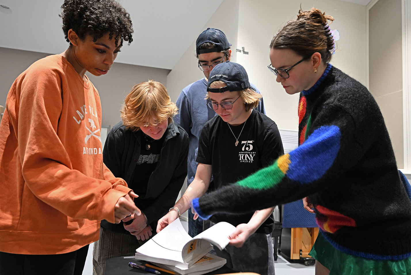 group of actors gather around script book