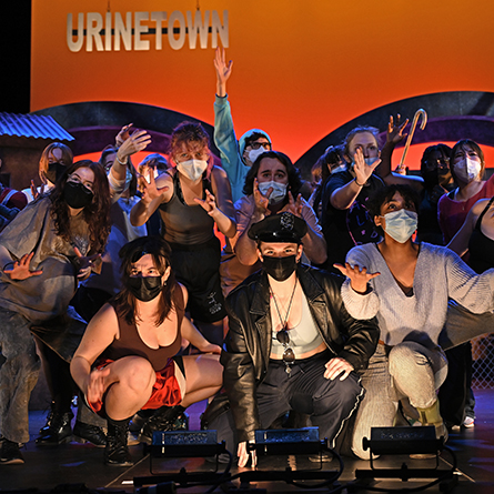 The cast of Urinetown performs during a tech rehearsal.