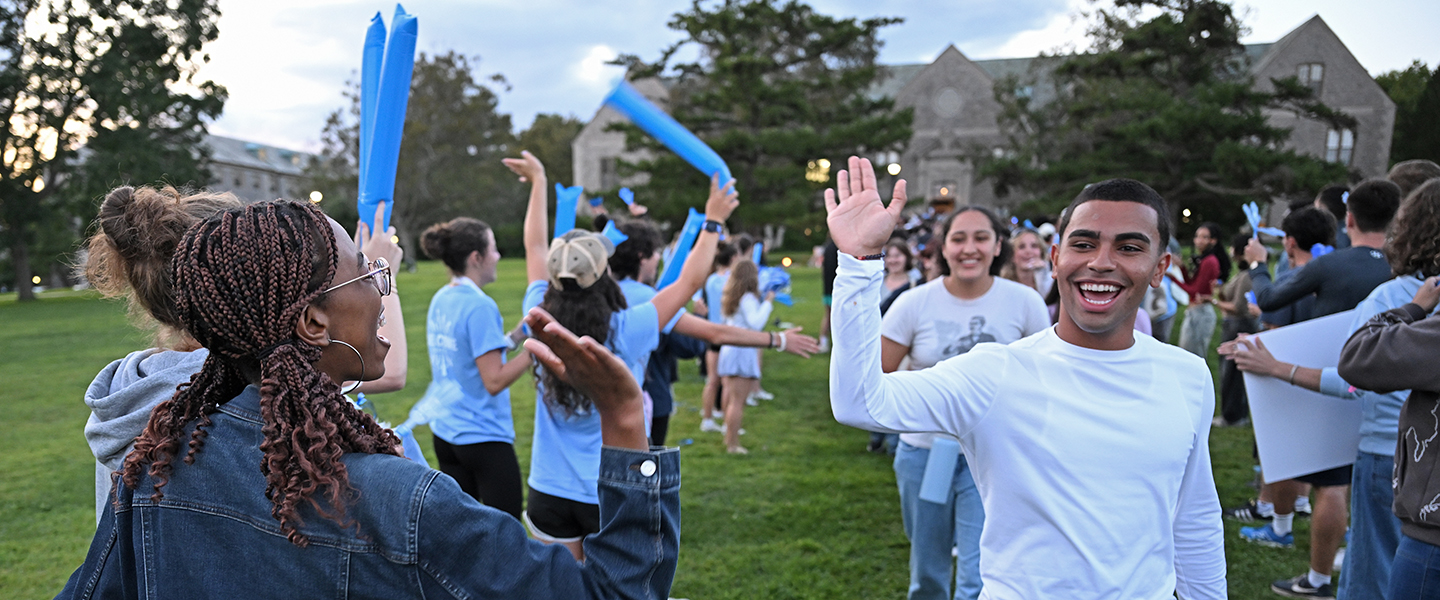 Student leaders high five new students as they take their 